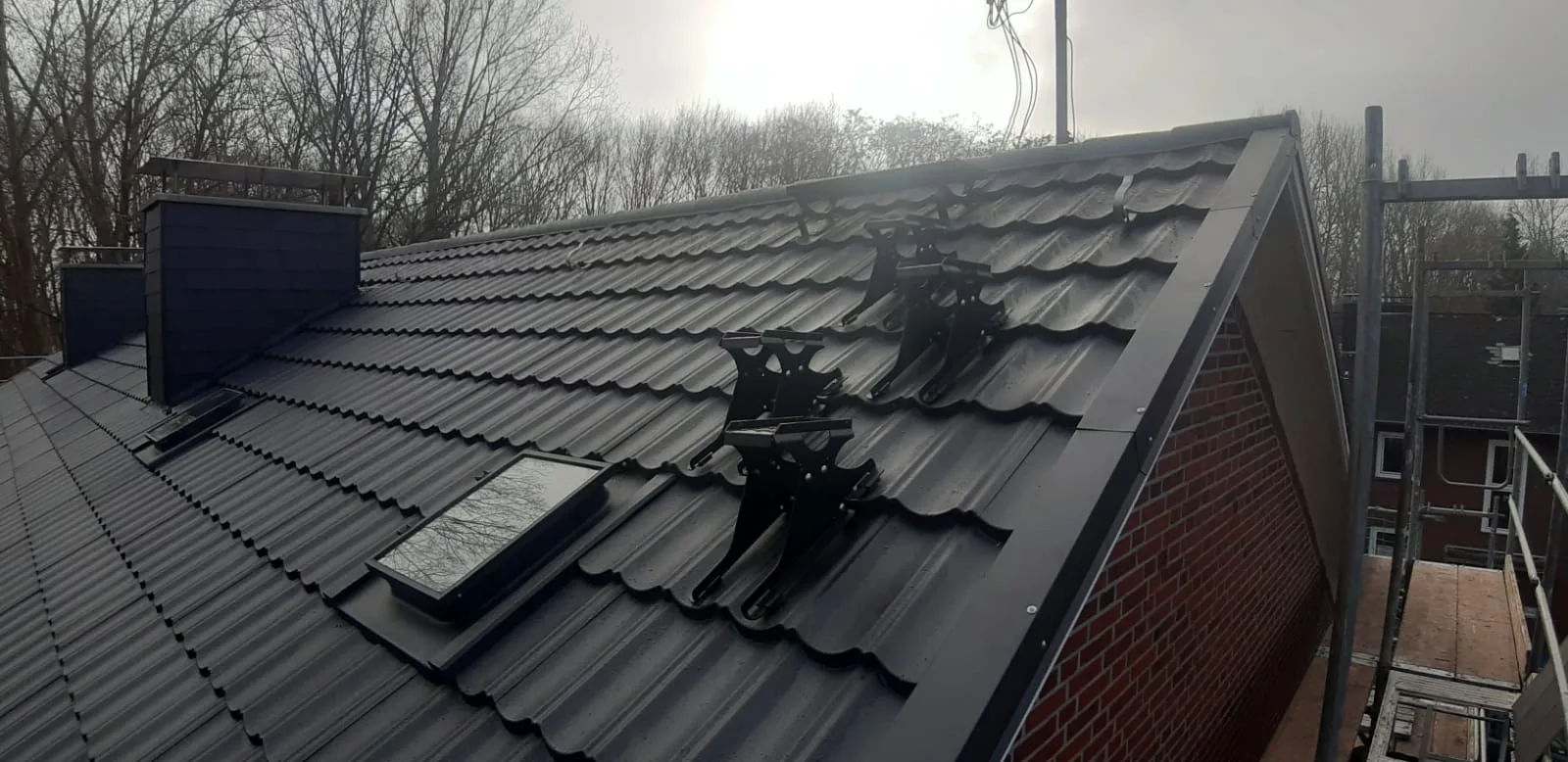 Neues schwarzes Metalldach in Pfannenoptik auf der Vorderseite des Hauses in Münster nach der Asbestsanierung
