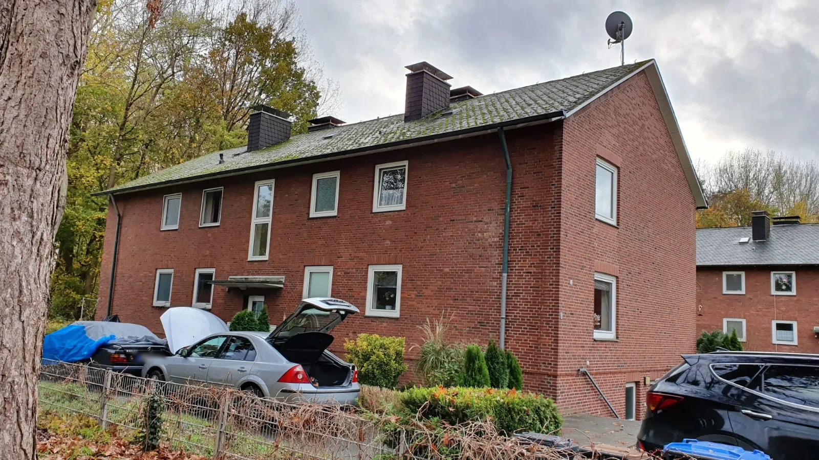 Mehrfamilienhaus aus rotem Klinker in Münster mit altem Asbestzement-Dach vor der Sanierung