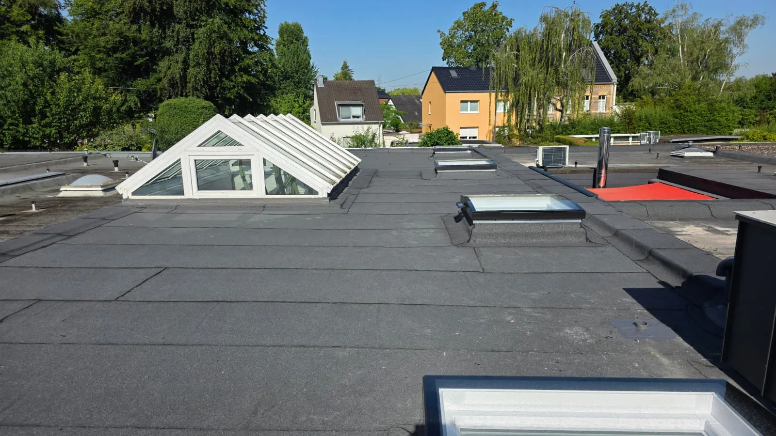 Saniertes Bitumen-Flachdach mit Lichtkuppeln und Lichtband in Köln – nachher