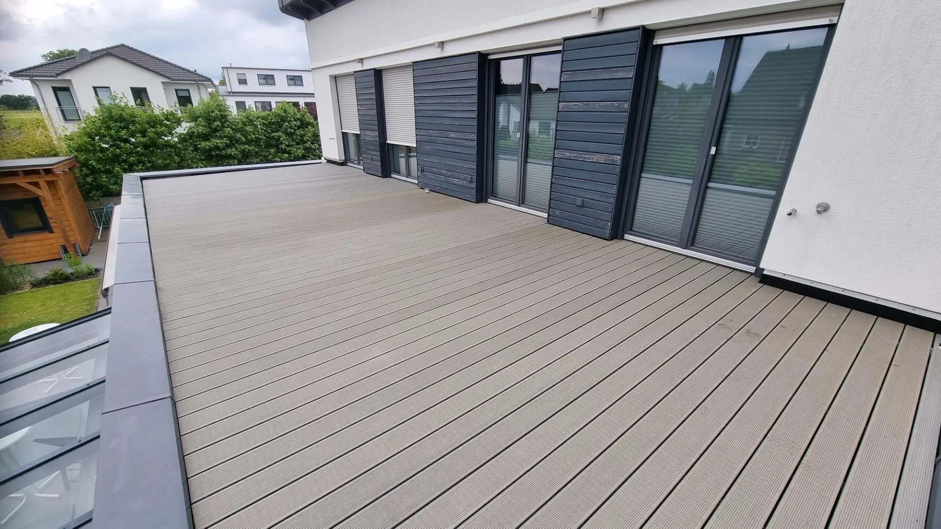 Sanierte Dachterrasse mit grauen WPC-Dielen und Alu-Randabschluss in Rheinberg – Terrassensanierung durch Baumeister