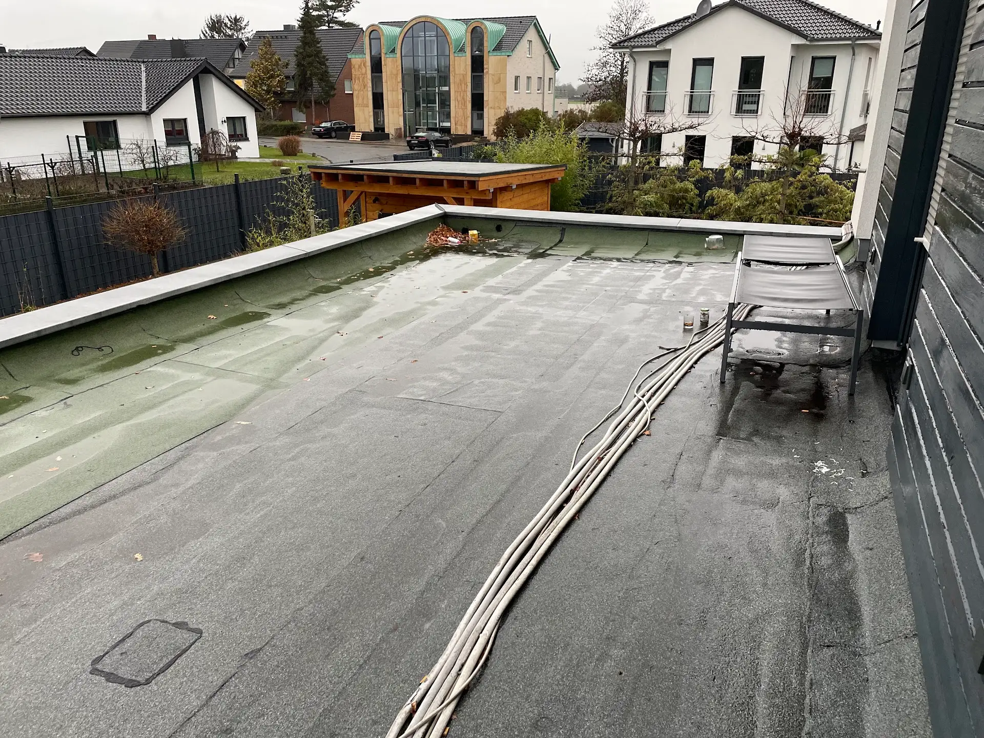 Dachterrasse in Rheinberg vor der Sanierung mit alter Bitumenabdichtung und losen Kabeln
