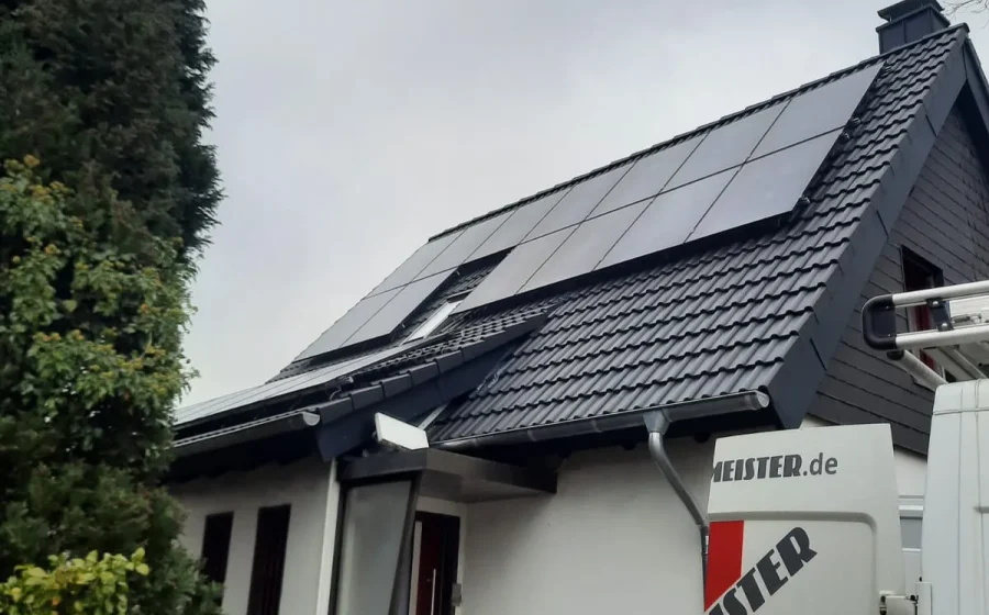 Wohnhaus in Duisburg mit neuem dunklen Steildach und PV-Anlage, Firmenwagen von Baumeister davor