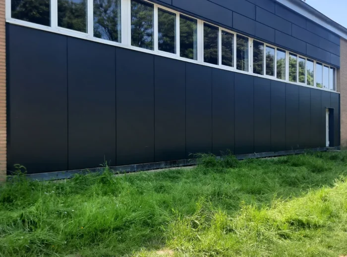 Neue vorgehängte Fassade aus dunklen HPL-Platten an einer Schule in Kamp-Lintfort