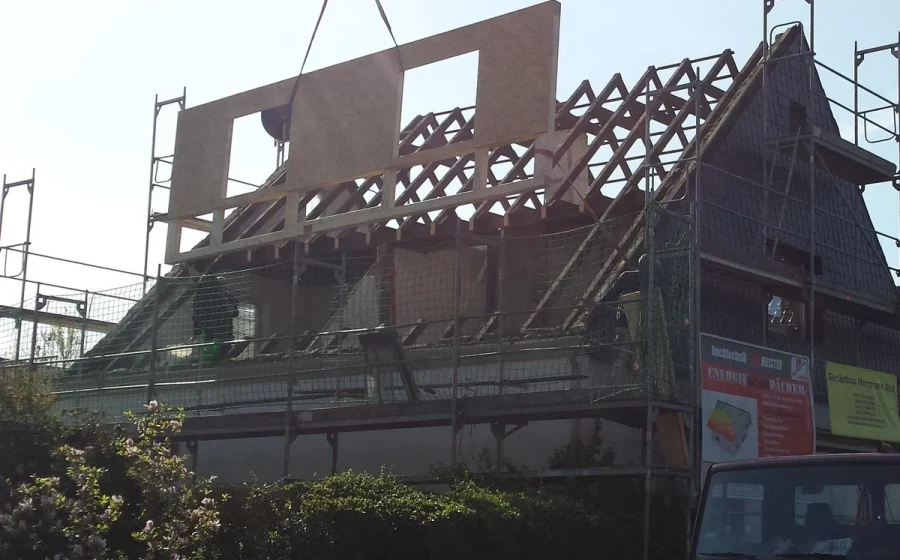 Neue Dachgaube wird per Kran auf einen Altbau gesetzt