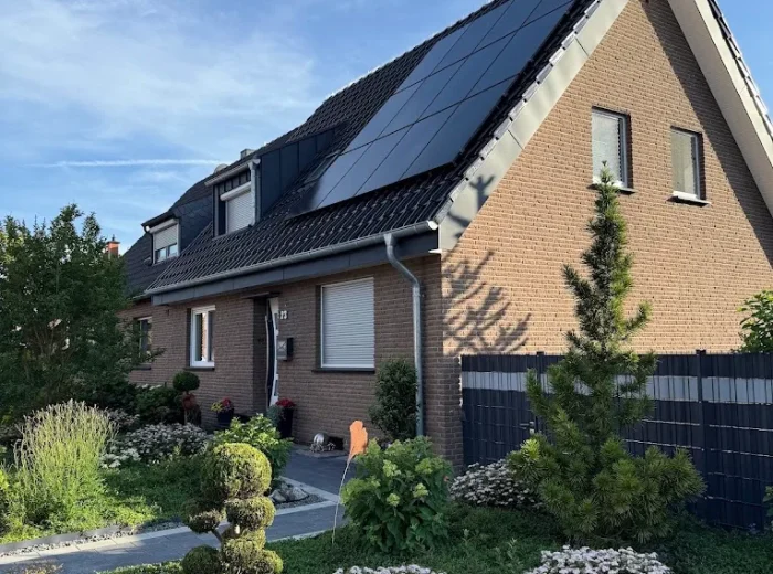 Full-Black-PV-Anlage auf dem Steildach eines Klinker-Einfamilienhauses mit Vorgarten